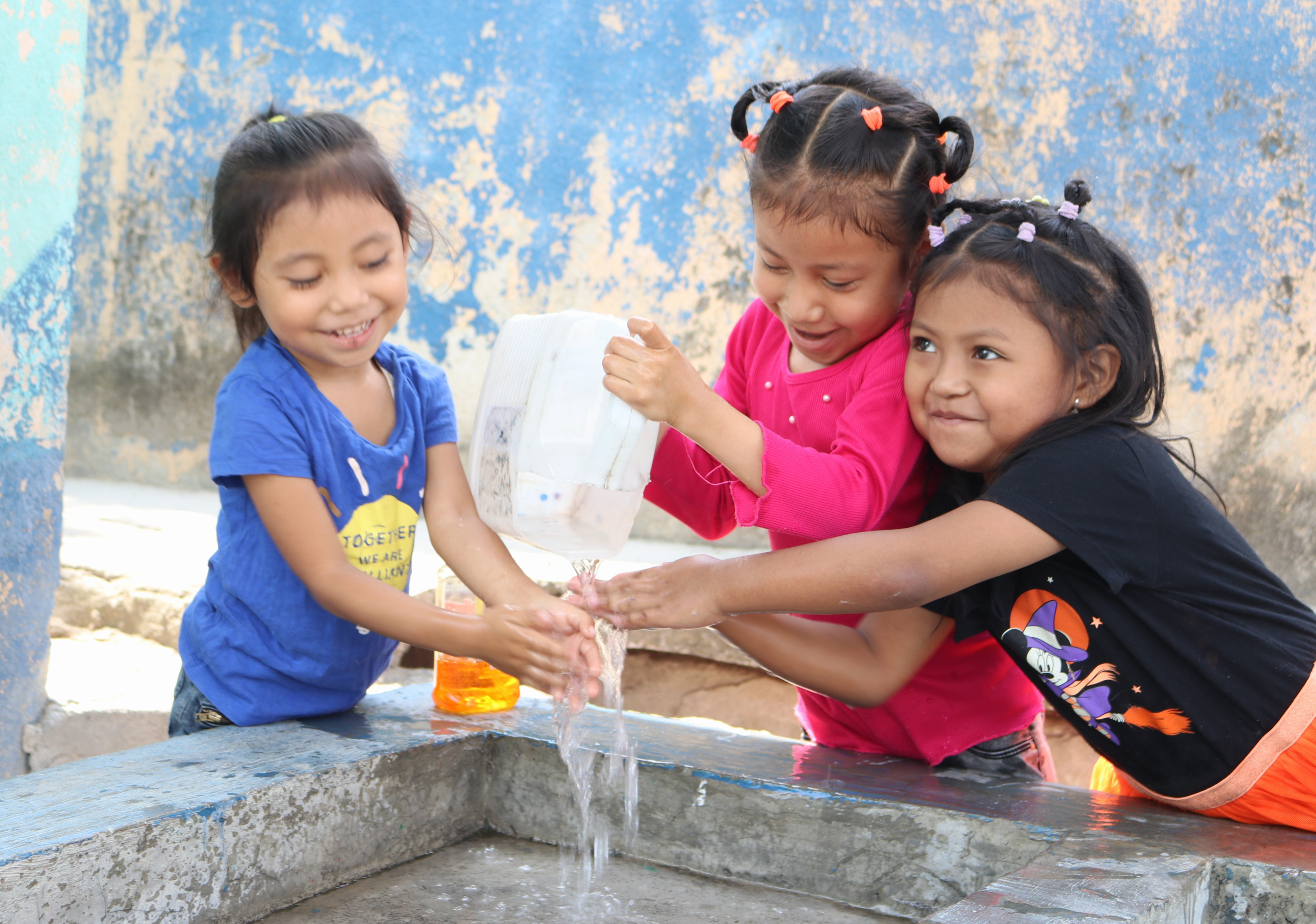 Children playing at a community water station